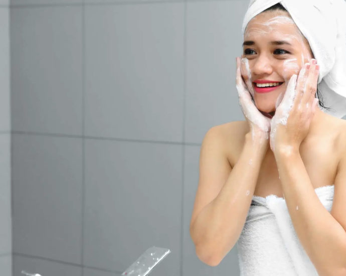 Young woman washing face for benefits of a skin care routine